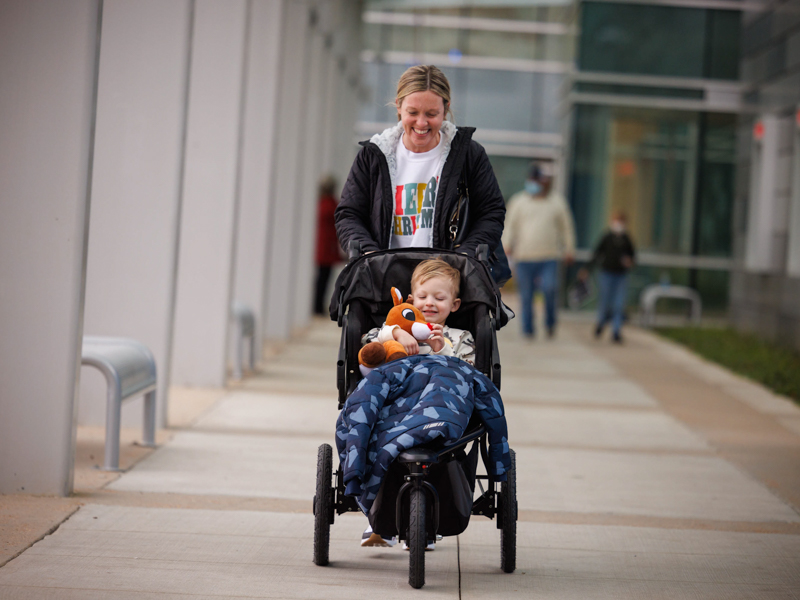 Morgan Ingram of Ridgeland smiles as son Parker Ingram plays with a stuffed reindeer from Nicholas Air as they leave the Kathy and Joe Sanderson Tower at Children's of Mississippi. Joe Ellis/ UMMC Communications 